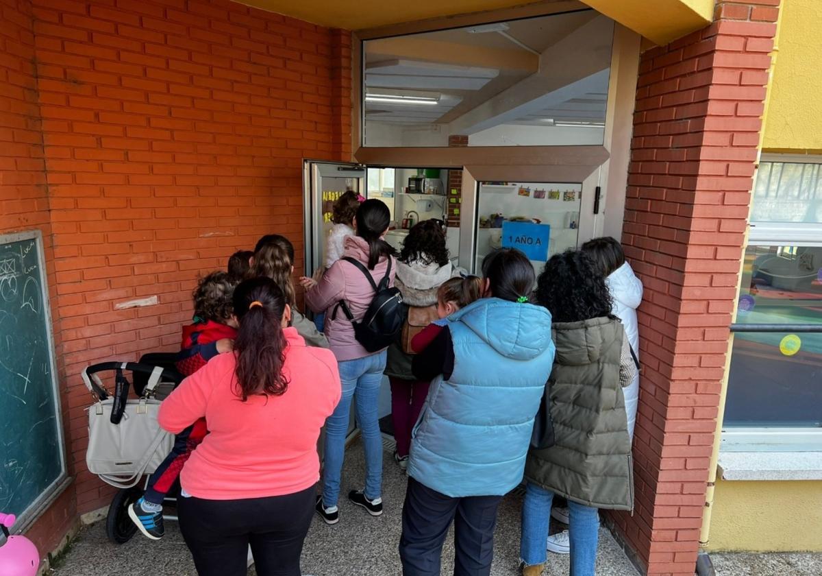 Las madres con sus bebés en brazos entrando en el aula de un año para la que piden refuerzos.