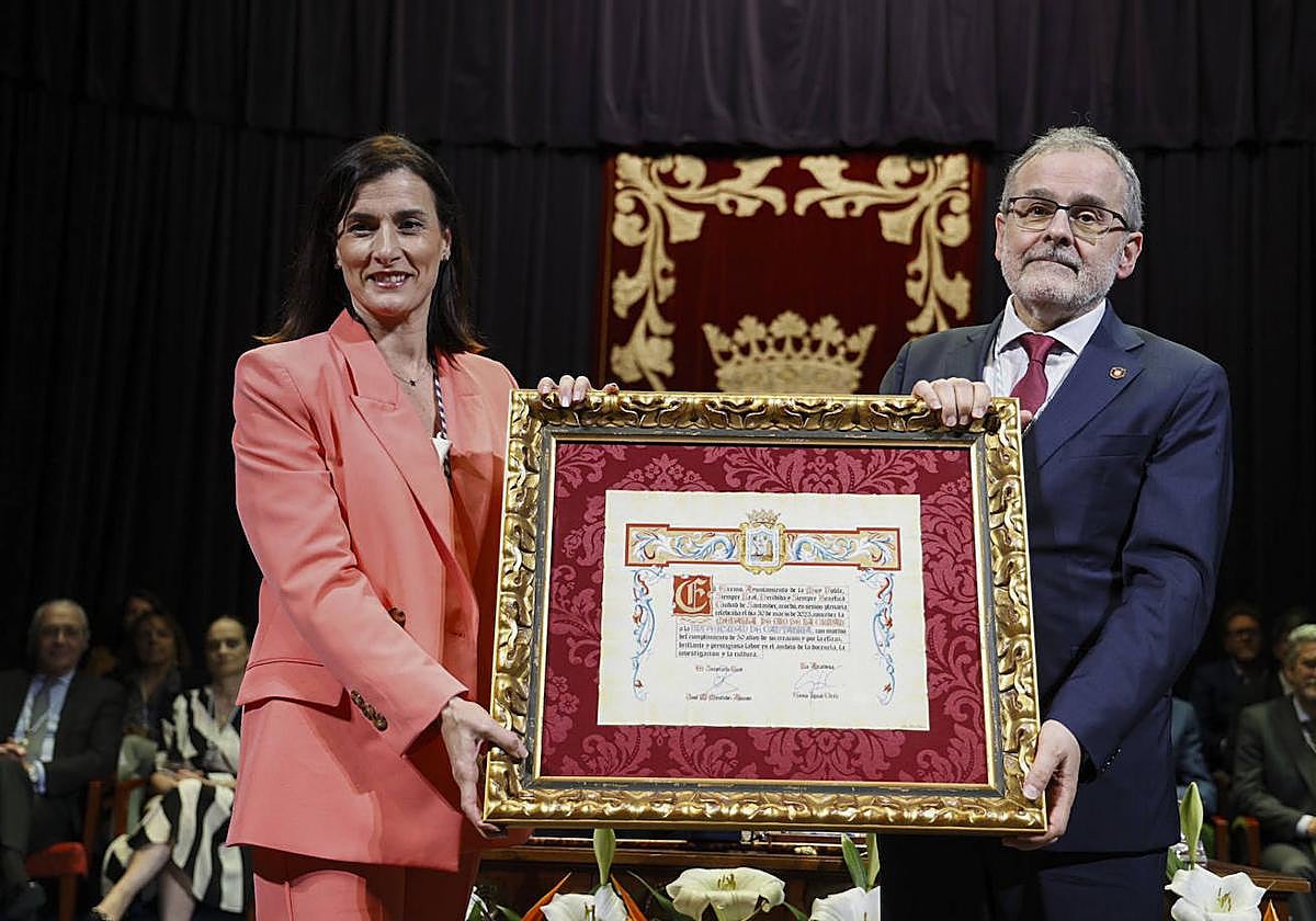 Gema Igual y Ángel Pazos muestran el documento que acredita la concesión a la UC de la Medalla de Oro de Santander.