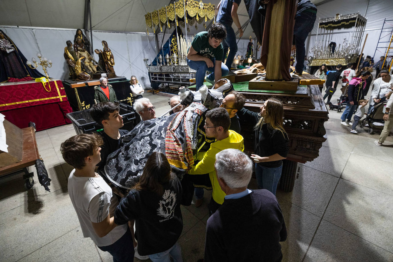 Una decena de hermanos de la Dolorosa ayuda a bajar la imagen de la Virgen. 