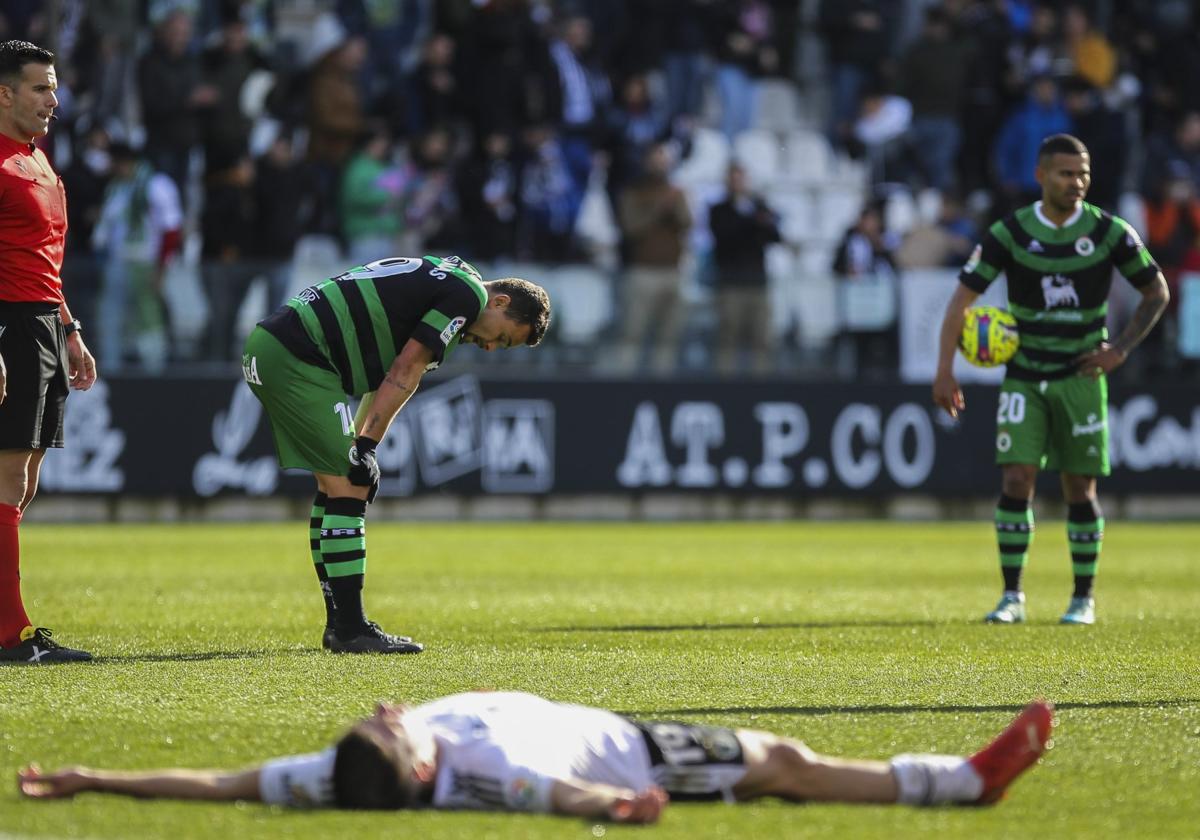 qMatheus y Juergen, con un jugador del Burgos tendido, tras la derrota del Racing en El Plantío.