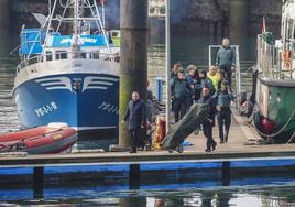 Agentes y personal del juzgado proceden al levantamiento de los cadáveres de los dos marineros fallecidos, trasladados al Puerto por el Siempre Nécora y el Ave Fénix.