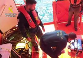 Efectivos de los Grupos Especiales de Actividades Subacuáticas de la Guardia Civil junto al robot submarino que ayuda en la búsqueda del maquinista del Vilaboa Uno.