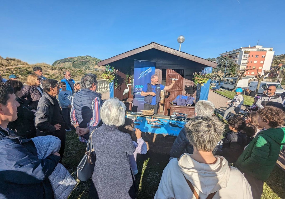 Público de todas las edades rodea el punto de información donde Diego de Vallejo informó en torno al proyecto 'Cetáceos del Cantábrico' de la Cofradía de Pescadores San Martín de Laredo.