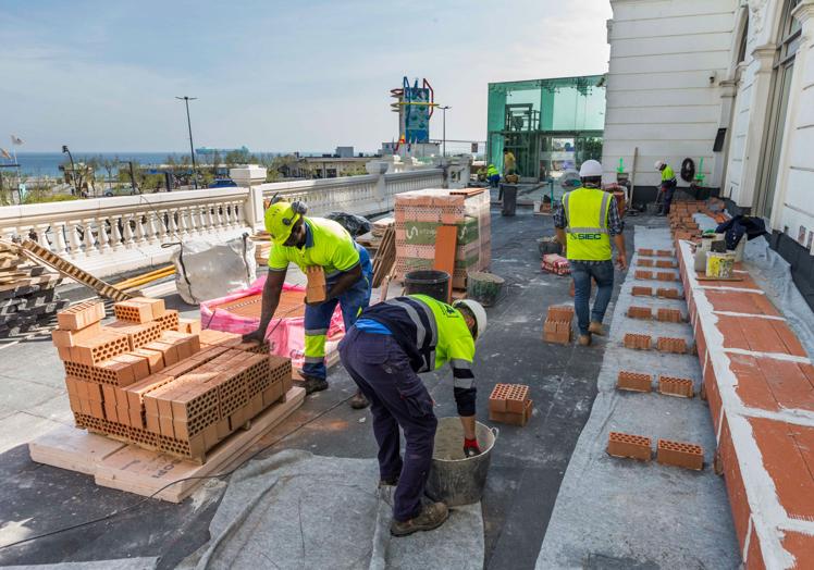 Imagen principal - Arriba: Últimos trabajos en la terraza. Abajo: Los operarios trabajan en la colocación de las molduras. Roberto Ruiz