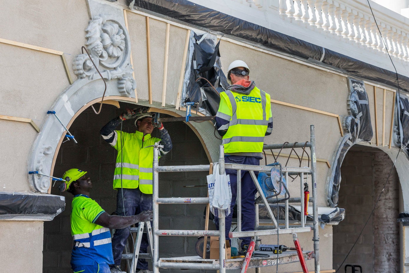 Los operarios trabajan en la colocación de las molduras.