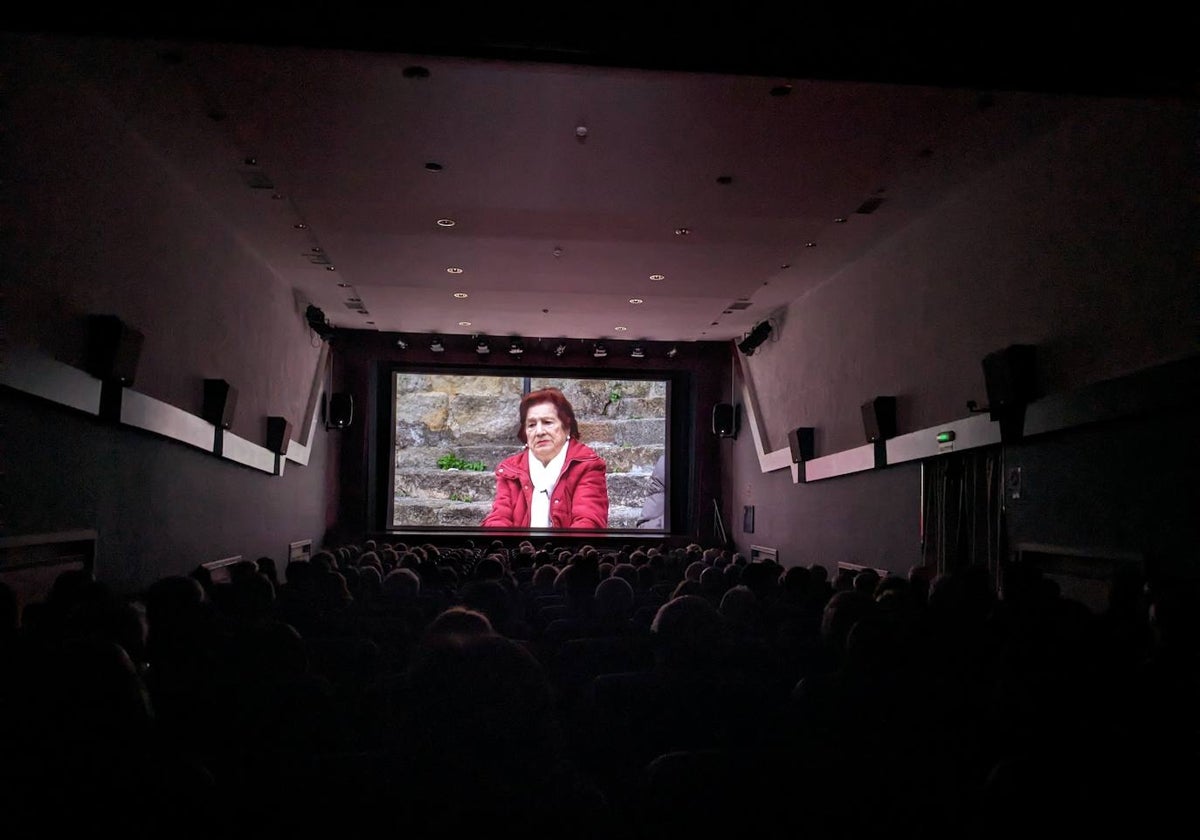 Una de las vecinas de la Puebla Vieja explicando sus vivencias en la proyección de un cine de Laredo abarrotado de público en el estreno del documental.