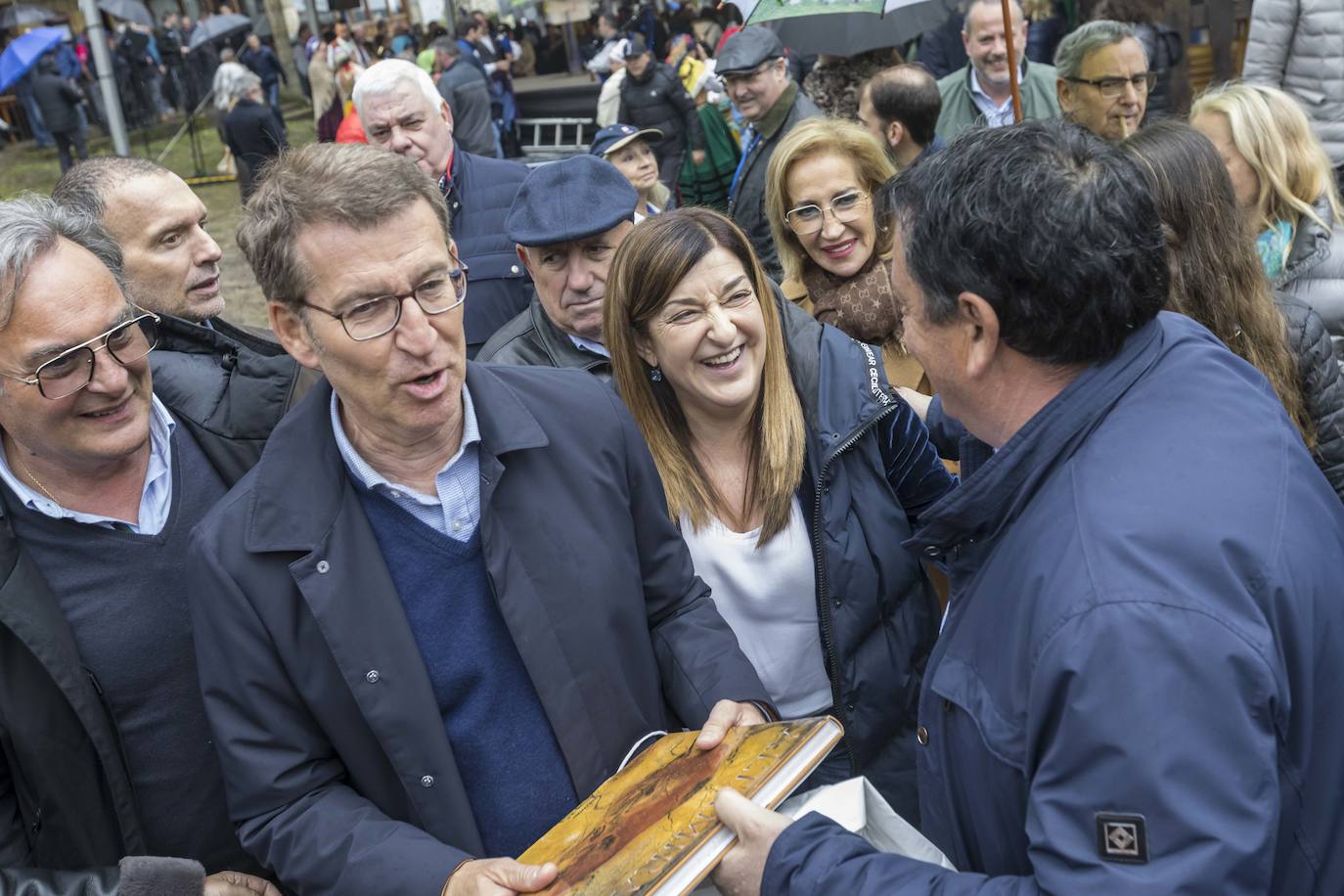 Uno de los asistentes entrega a Feijóo un libro sobre Altamira