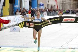 Irene Pelayo cruza la línea de meta de la maratón de Zaragoza para proclamarse campeona de España.