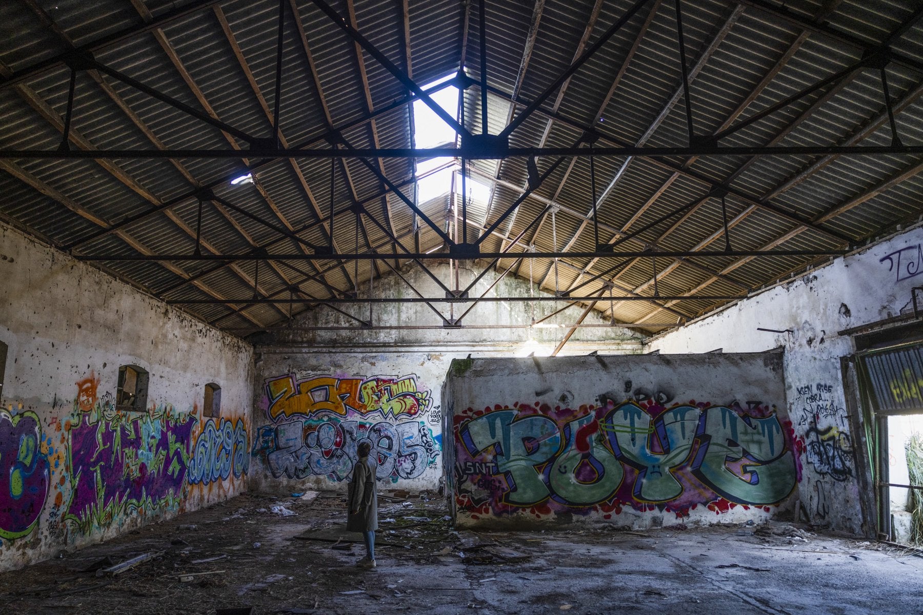 Una joven observa el interior de uno de los antiguos inmuebles militares abandonados que se encuentran en lo alto de la finca de La Remonta, en Santander.