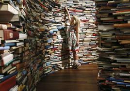 Una niña posa dentro de una instalación laberíntica formada por 250.000 libros.