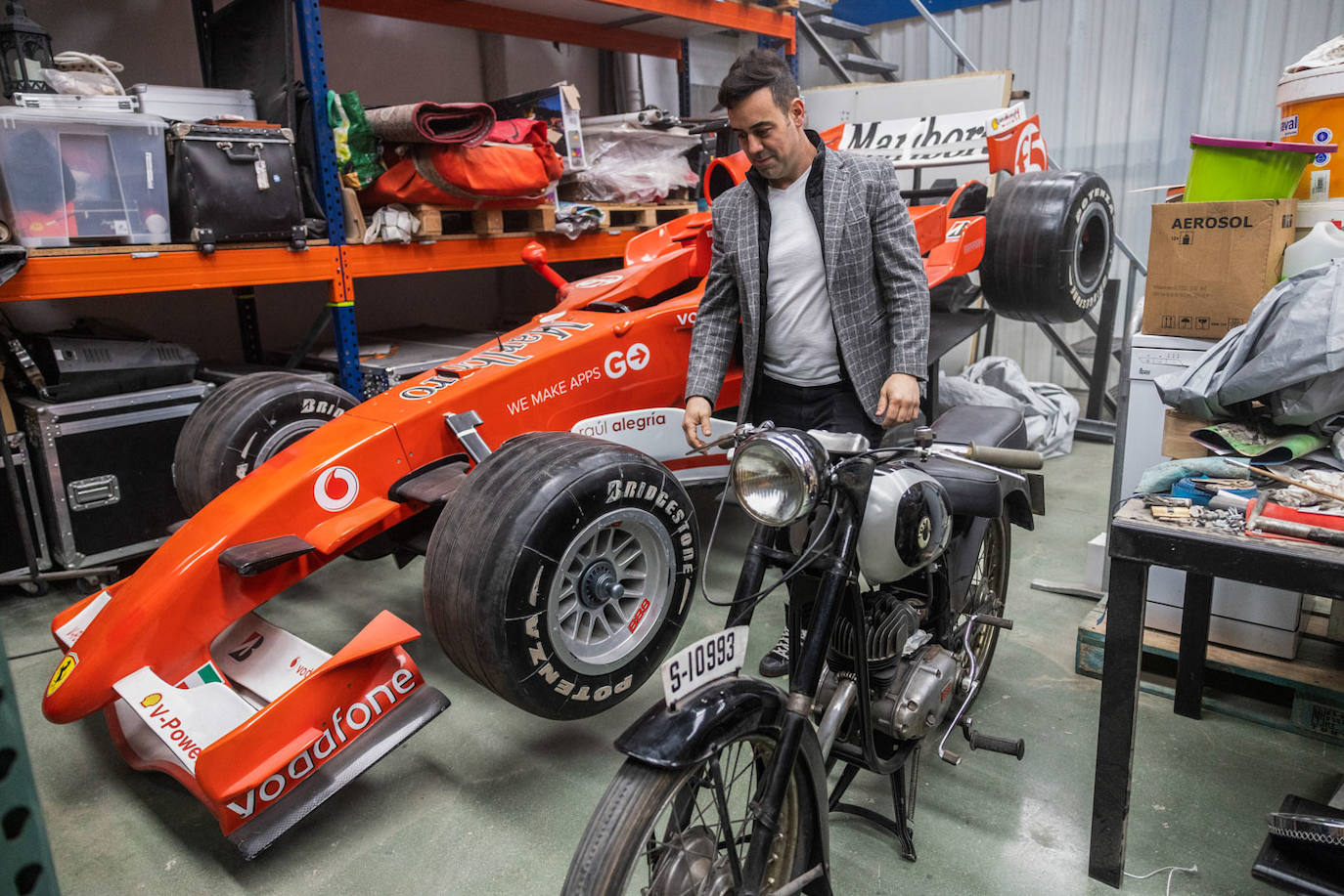 Raúl Alegría junto a dos de sus piezas más queridas: la motocicleta 'Ossa' de su abuelo y el prototipo de 'Ferrari' que utiliza en algunos de sus espectáculos.