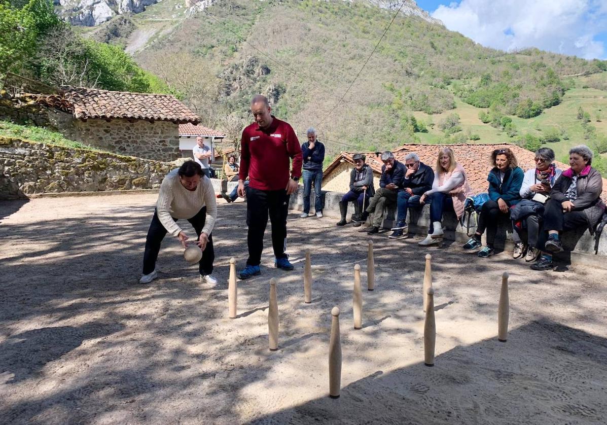 Una mujer se dispone a birlar los bolos en la bolera de la localidad de Bárago