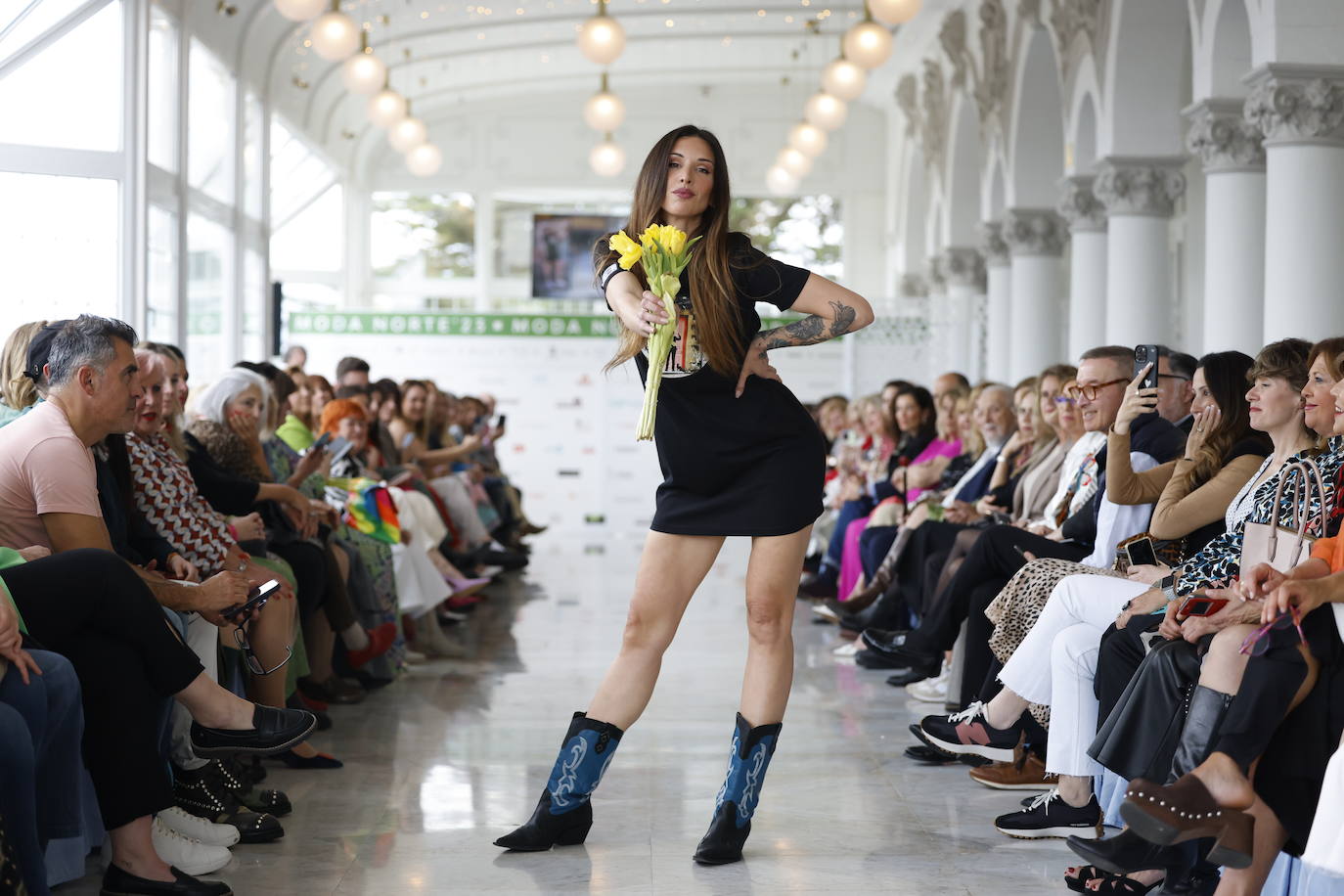 Lucilia Fernández con el vestido 'portal' en el que se ve «a un galán» con un ramo de flores. Durante la pasarela, la modelo lució el mismo ramo que el dibujo del vestido.