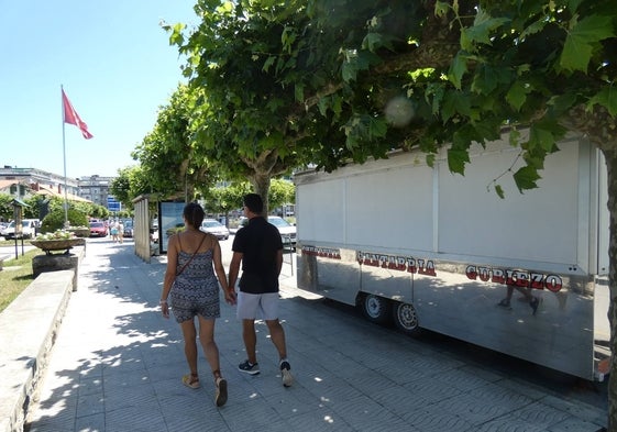 Una pareja camina junto a una de las dos churrerías cuya explotación sale a concurso en la presente convocatoria de puestos de temporada estival.