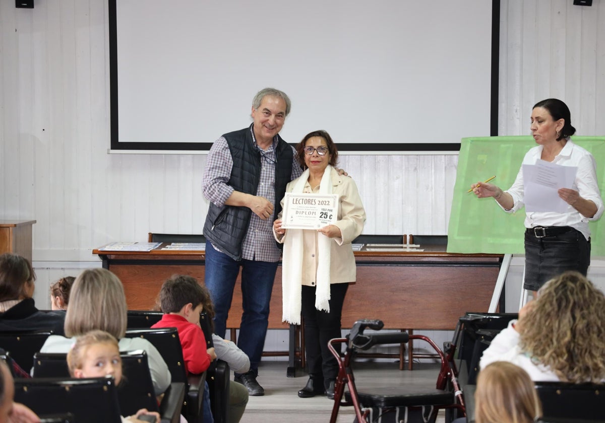 Javier Gómez, alcalde de Potes entregando un premio a una de las mejores lectoras del año