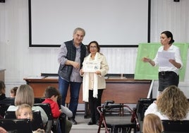 Javier Gómez, alcalde de Potes entregando un premio a una de las mejores lectoras del año