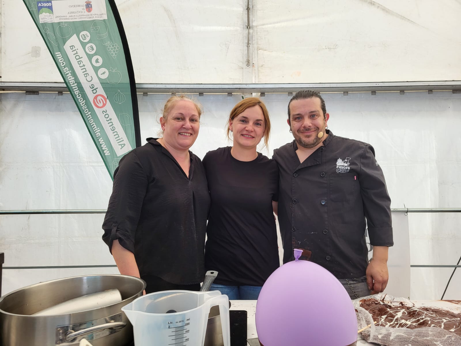 La concejal regionalista Ana Obregón con cocineros participantes en la feria.