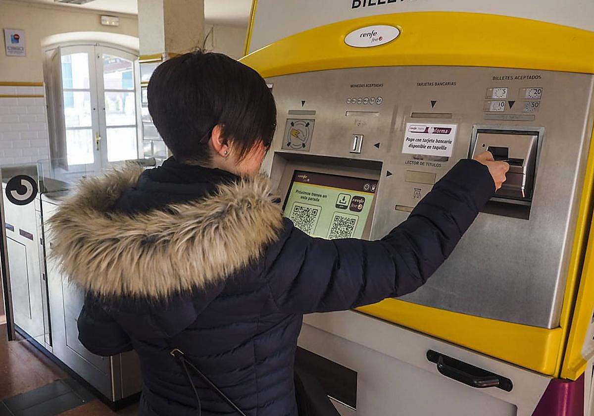 Una usuaria, en la estación de tren de Maliaño, saca su abono gratuito para viajar en la red de Cercanías.