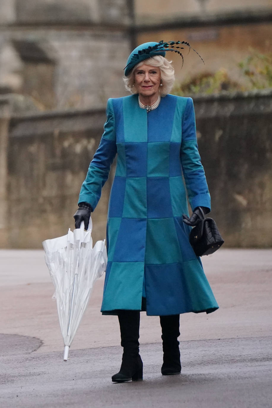 Camilla con un original abrigo-vestido de parches a juego con tocado con plumas. 