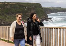 Mercedes González y Mónica Rodero pasean junto a la playa de Los Locos, en Suances.