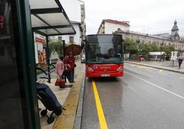 Usuarios del Torrebús aguardan a la llegada de un autocar, en la calle Julián Ceballos de Torrelavega