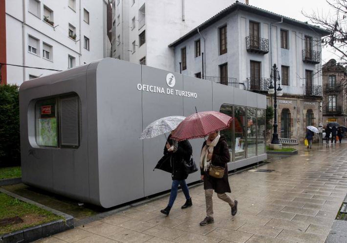 Vecinas caminan junto a la Oficina de Turismo de Torrelavega, en la plaza de Pequeñeces.