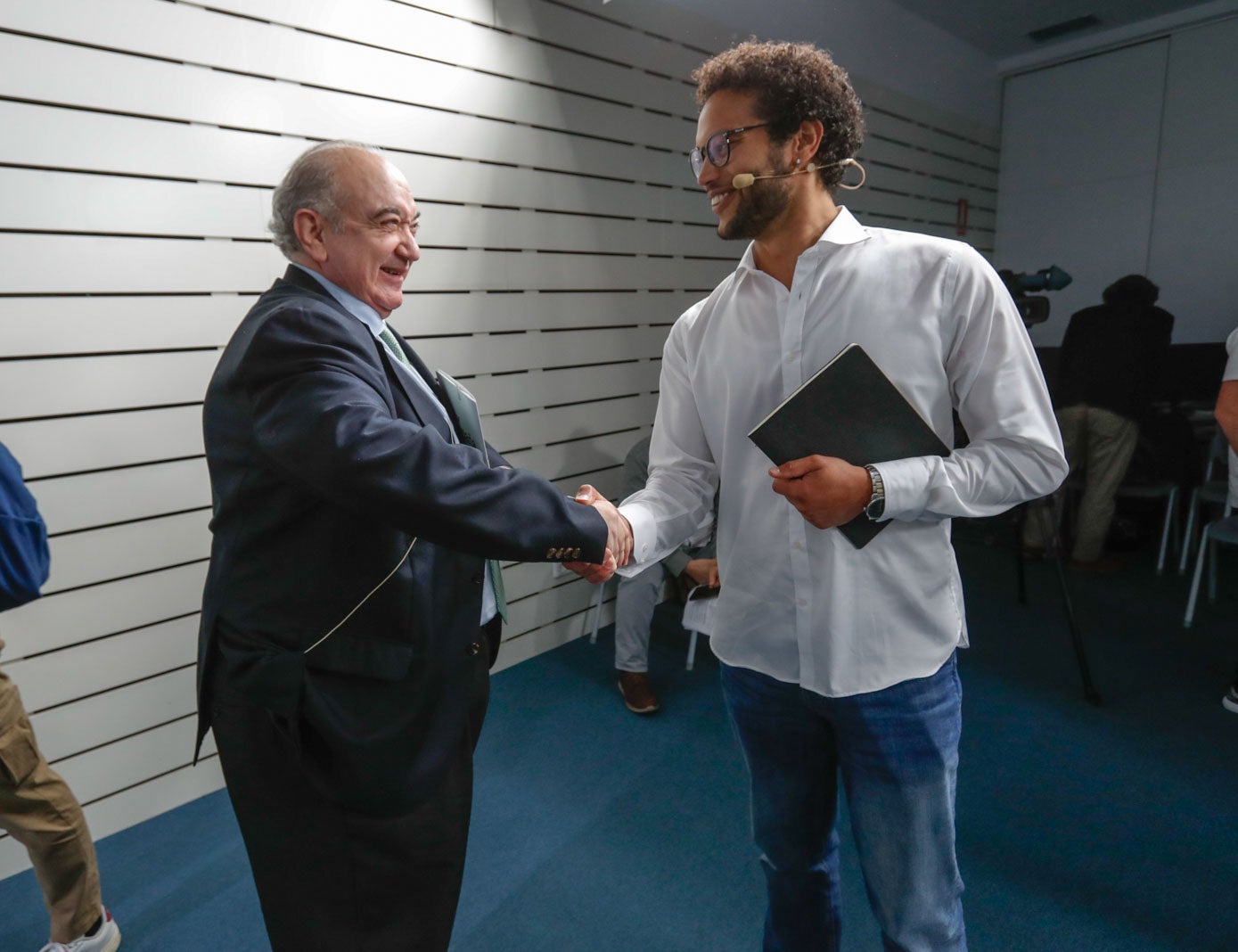 Keruin Martínez (IU-Podemos) se saluda con Emilio del Valle (Vox) antes de comenzar el debate.