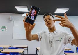 Alae Arce Cubiles, en su aula del Colegio Kostka de Santander donde estudia 2º de la ESO, con una foto de Felipe VI en el teléfono móvil.