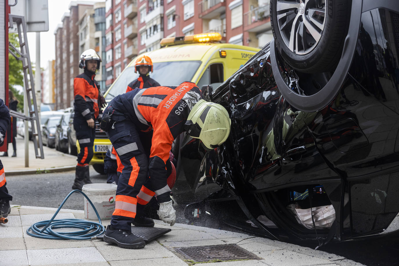 Los bomberos de Santander se han encargado de despejar la vía, para lo que han tenido que voltear el coche siniestrado.