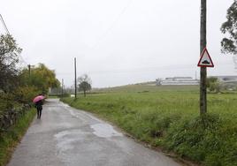 Una mujer camina a un costado de los terrenos de Las Excavadas, ayer, en el suroeste de Torrelavega.