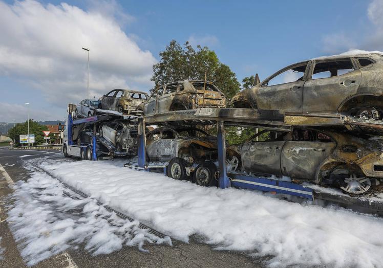 Imagen principal - Los vehículos del remolque, totalmente calcinado por las llamas, ocupan la salida hacia Viérnoles (Torrelavega) de la autovía A-67. 