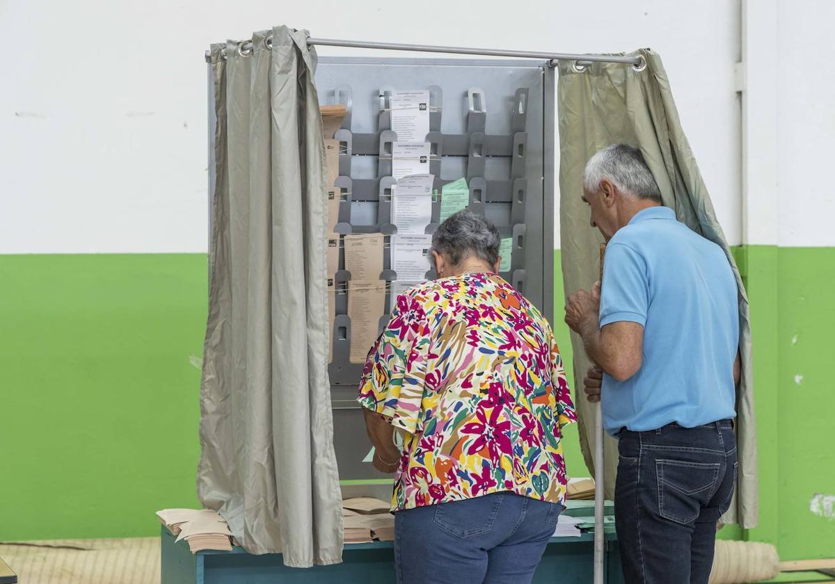 Dos electores votan, esta mañana, en Renedo de Piélagos.