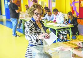 Una vecina deposita su voto en una urna de Colindres.