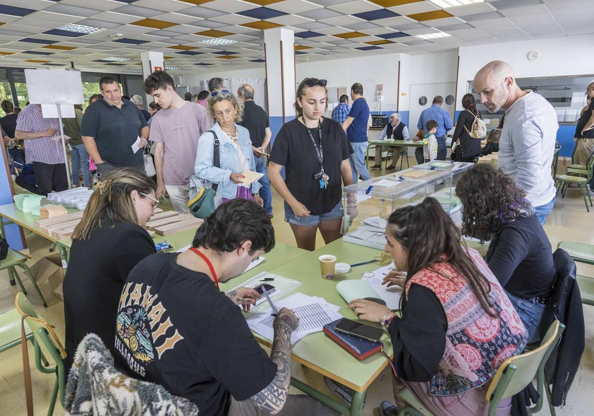 Votantes, en Santa Cruz de Bezana, aguardan para introducir las papeletas en las urnas.