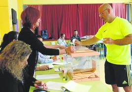 Un vecino deposita su voto en una de las mesas electorales de Colindres.