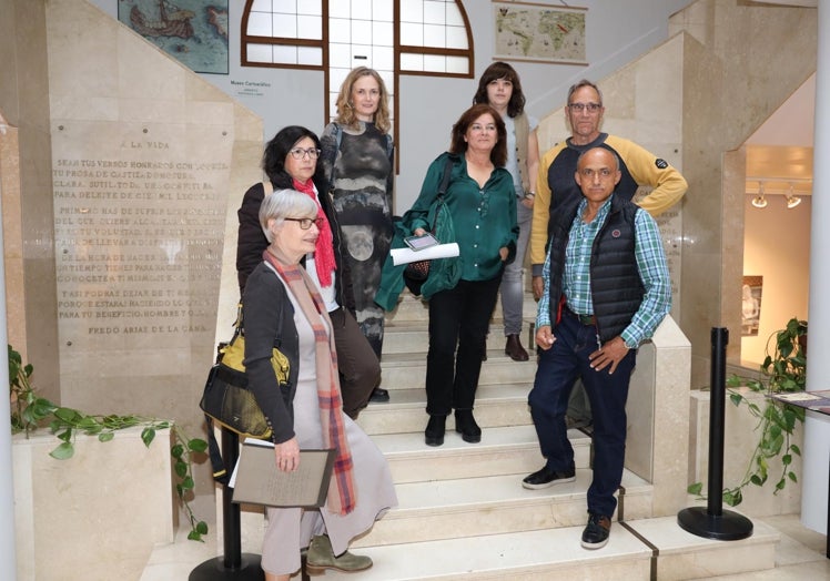 Imagen principal - Chema Prieto con los poetas que intervinieron en el acto, y Silvia Prellezo y Maribel Fernández leyendo sus poemas