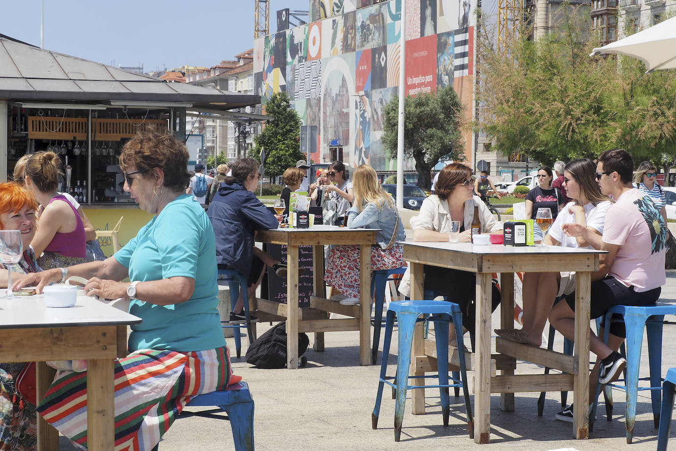 Todas las mesas ocupadas en el bar del paseo marítimo junto a las taquillas de las pedreñeras.