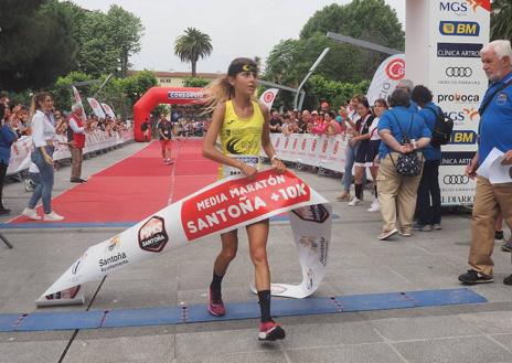 Imagen secundaria 1 - La ganadora Alejandra Sánchez (de amarillo) y la santoñesa Dolores Marco, en el momento de llegar a la línea de meta.