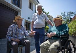 Evaristo Domínguez conversa con dos vecinos en una de las calles de San Miguel de Meruelo.