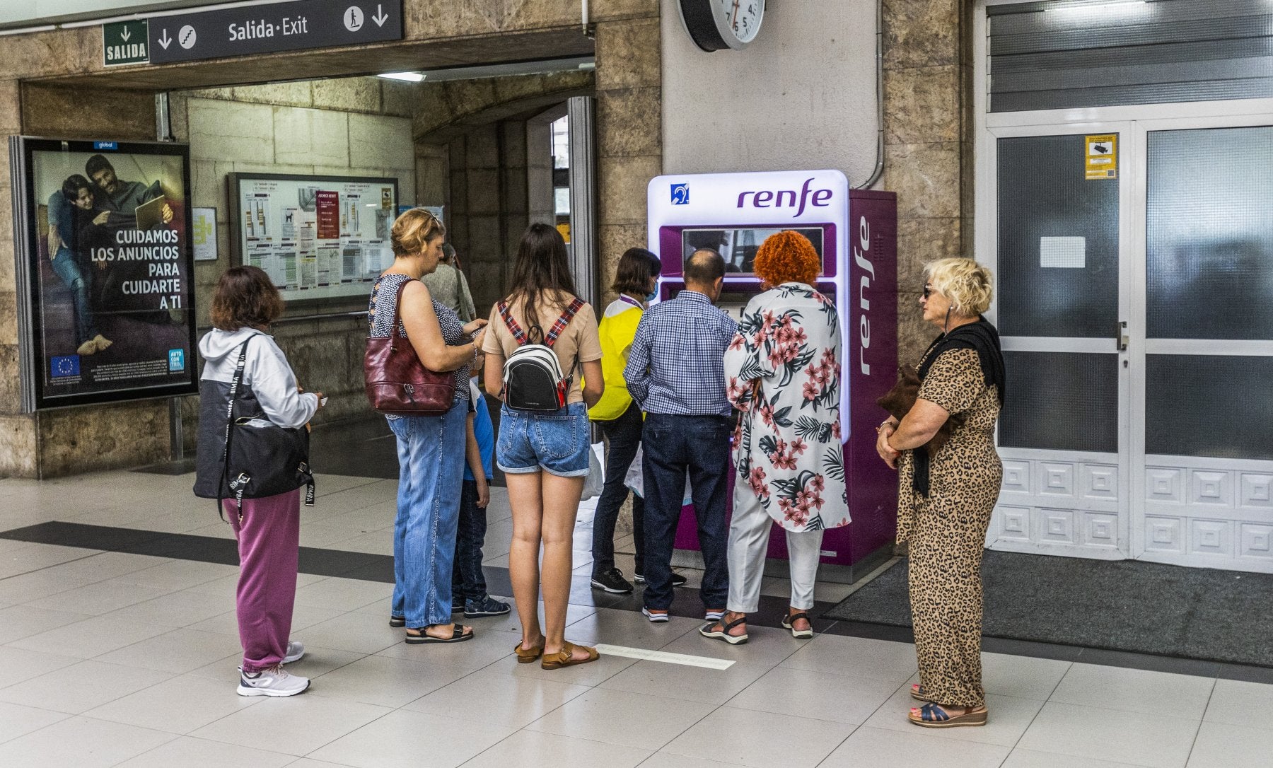 Un grupo de usuarios de la red de Cercanías de Cantabria, sacando el abono de transporte gratuito en la estación de Santander.