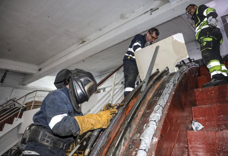 Imagen principal - Varios operarios trabajan en la reparación de los daños observados en la estación inferior del teleférico.