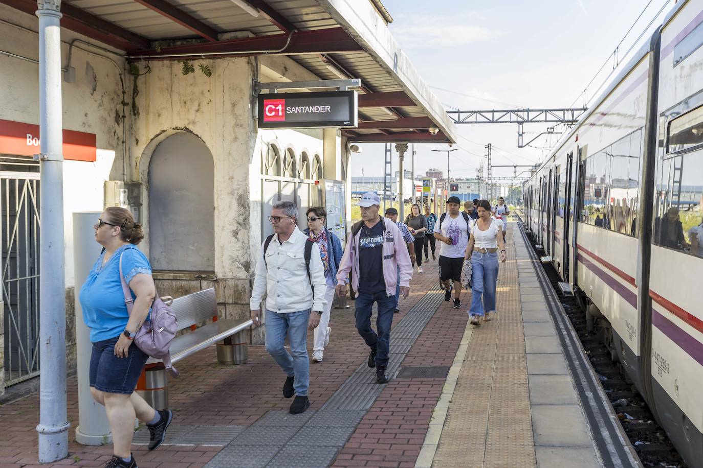 Los usuarios afectados por las obras de la duplicación de la vía entre Santander y Muriedas abandonan la estación de Boo de Guarnizo para subirse al autobús.