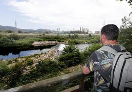 Un joven observa el lugar en el que se inició la obra en el río Saja-Besaya hace cuatro años.