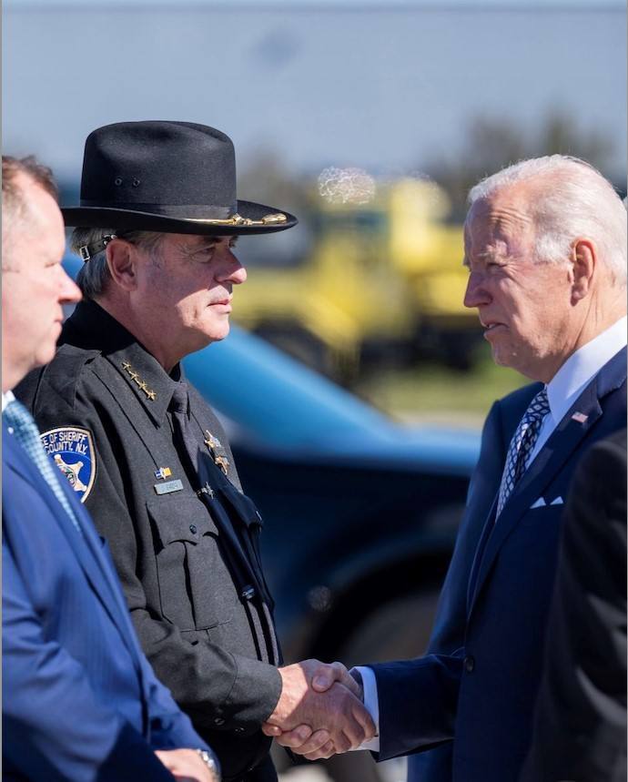 Juan Carlos García, sheriff del condado de Erie (Nueva York), estrecha la mano del presidente de Estados Unidos (EE UU), Joe Biden, durante un acto de bienvenida en el aeropuerto de Búfalo.