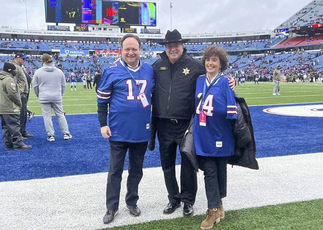 El sheriff posa con su sobrino, Ramón López, y la esposa de este, Marta, en el Highmark Stadium de los Buffalo Bills, el equipo de fútbol americano del condado de Erie (en el estado de Nueva York). 