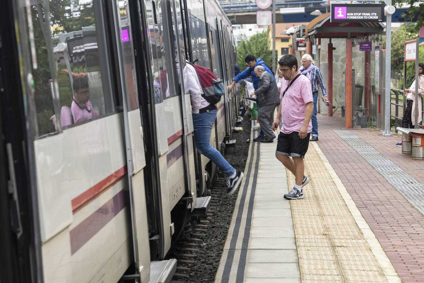 Varios viajeros suben al tren en el apeadero de Renfe de Muriedas.