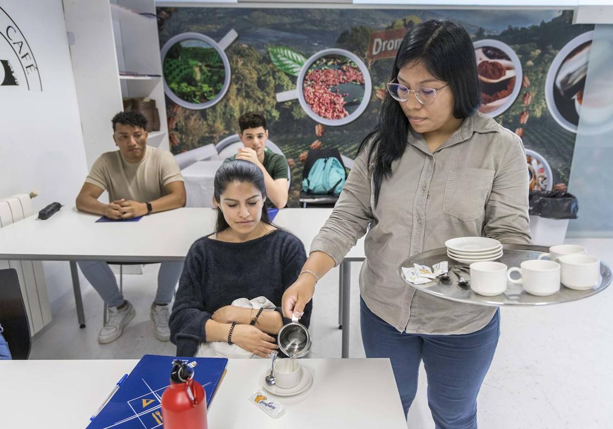 Una de las alumnas del curso de hostelería, en el Hotel Escuela Las Carolinas, practica a llevar una bandeja y servir unos cafés.