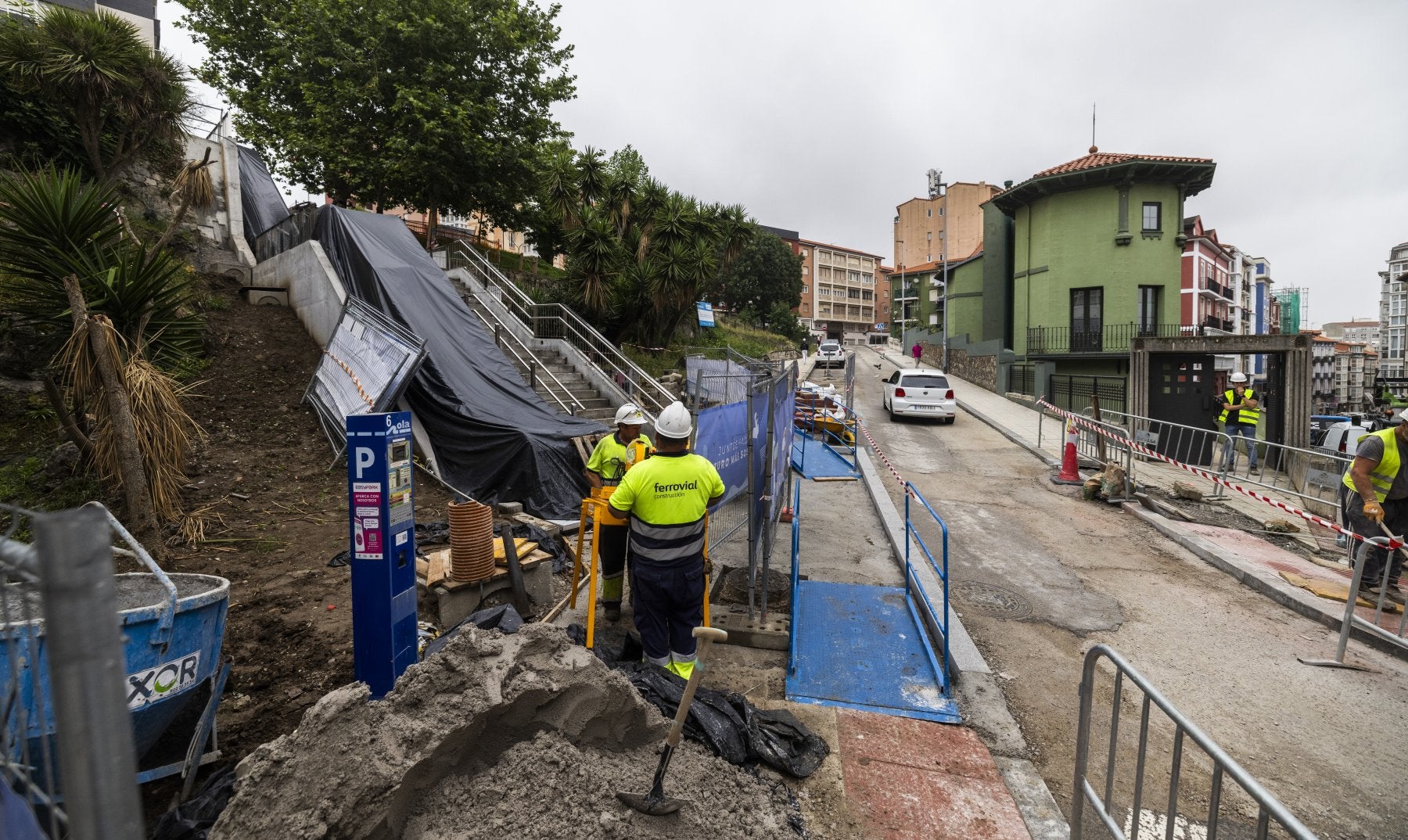 Varios operarios trabajan en las obras del itinerario mecánico entre Jesús de Monasterio y Juan XXIII, a la altura del parque Recaredo, en Cisneros. Los operarios, ayer, tapando las escaleras mecánicas por la lluvia.