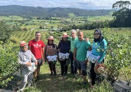 Dani, su padre Eduardo López y Hassan, junto a cuatro recolectoras marroquíes, en una finca de Güemes.