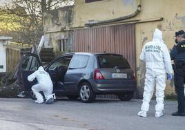 Dos agentes de Criminalística analizan el coche de la víctima después de cometerse el crimen.